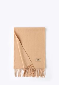 Sciarpa di lana morbida e color sabbia con bordi frangiati e una piccola etichetta decorativa. Tessuto liscio con un angolo piegato che rivela il lato sottostante.
