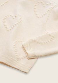 Strickpullover in Creme mit Herzmustern. Mit gerippten Bündchen und Saum, weichem Material und rundem Halsausschnitt.