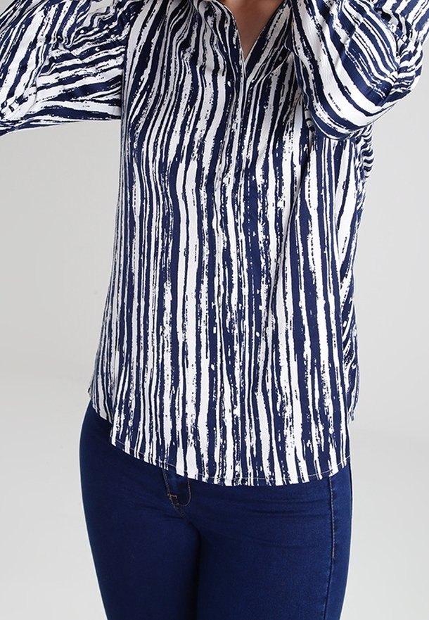Camicetta a righe blu navy e bianche realizzata in tessuto leggero, con colletto e maniche lunghe con polsini abbottonati.