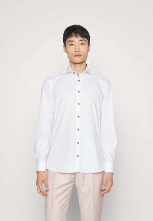 White button-up shirt made of smooth fabric with a structured collar, featuring black buttons along the front. Tailored fit, long sleeves.