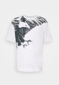 Bílý bavlněný tričko s velkým černým grafickým vyobrazením orla na přední straně, zobrazujícími složité detaily křídel a drápů. Krátké rukávy.