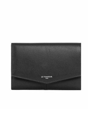 Portefeuille en cuir noir avec une fermeture à rabat. Texture lisse, forme rectangulaire et logo embossé "LE TANNEUR 1898" à l'avant.
