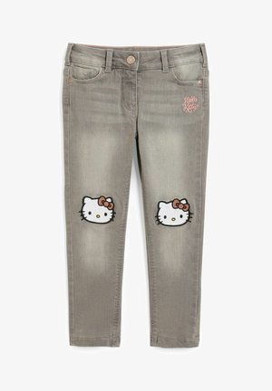 Grå børnejegins med Hello Kitty-ansigtspatches på knæene og lyserød "Hello Kitty" broderi på frontlommen.