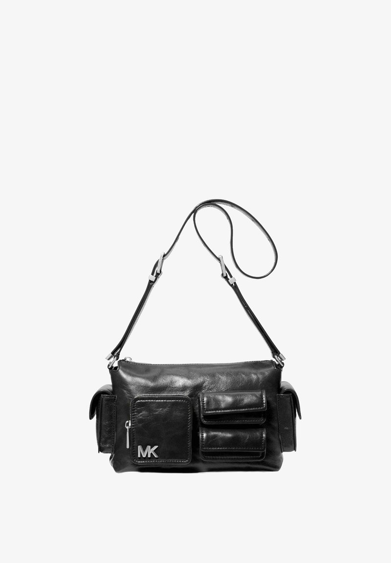 Bolso de hombro de cuero negro con dos bolsillos frontales, herrajes plateados, correa ajustable y logo de MK en el lateral. Textura suave y forma rectangular.