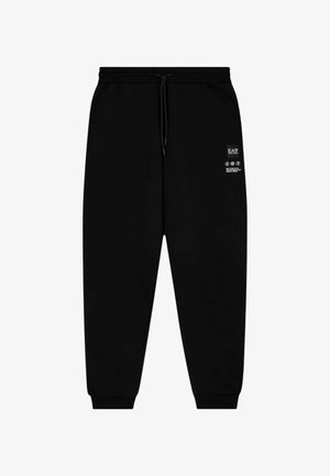 Pantaloni della tuta neri con vita elasticizzata e coulisse regolabile. Toppa con logo sulla coscia sinistra. Orli risvoltati con una texture liscia.