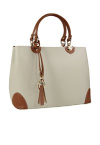 Sac à main beige avec des accents en cuir marron, deux poignées courtes et un détail de pompon. Fabriqué en matériau lisse et durable. Forme carrée.