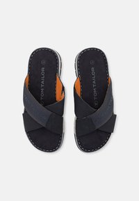 Marineblaue Sandalen mit strukturierten Kreuzriemen, orangen Akzenten und weißen Nähten. Weiches, samtartiges Material und gepolsterte Innensohle.