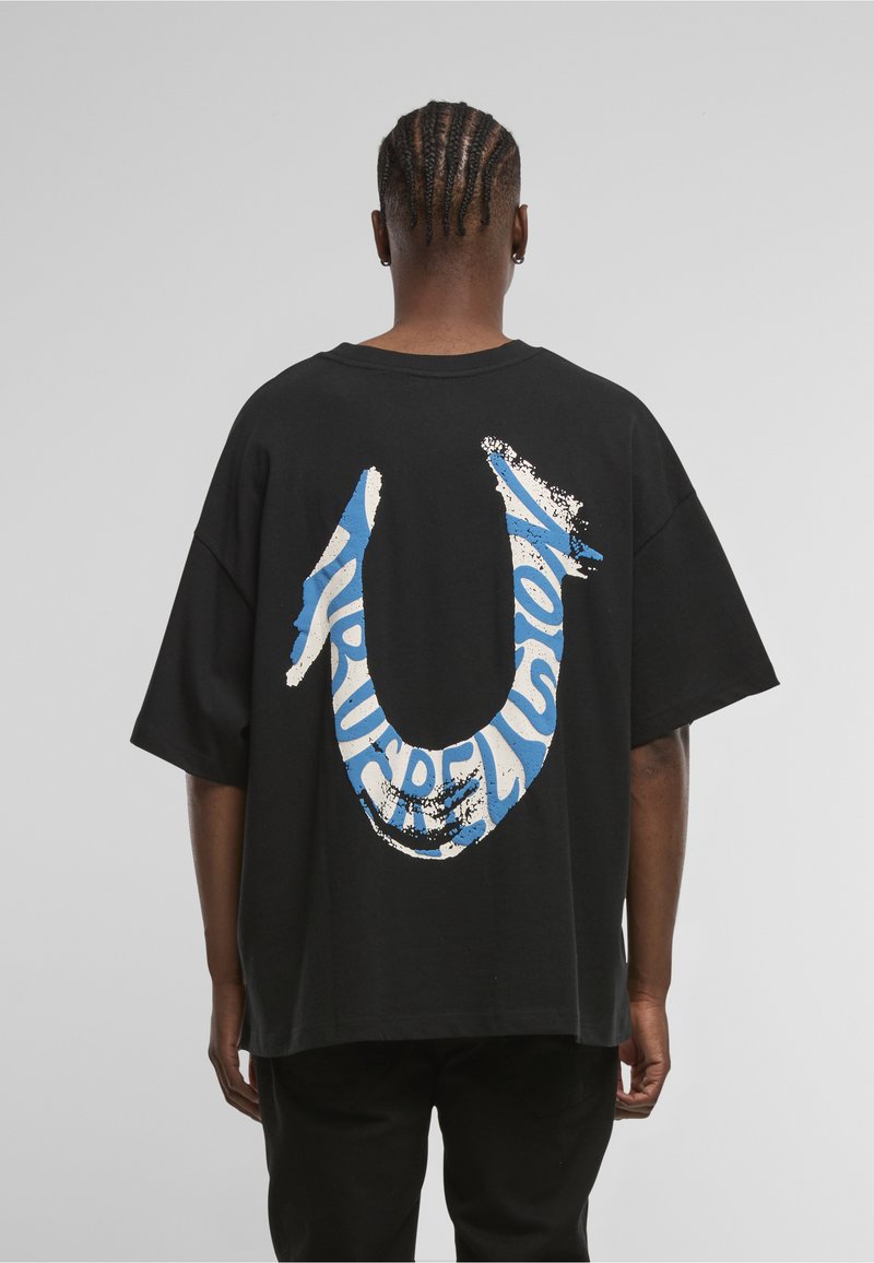 Czarny, oversize'owy t-shirt z dużym niebiesko-białym logo na plecach. Krótkie rękawy, okrągły dekolt i luźny krój.