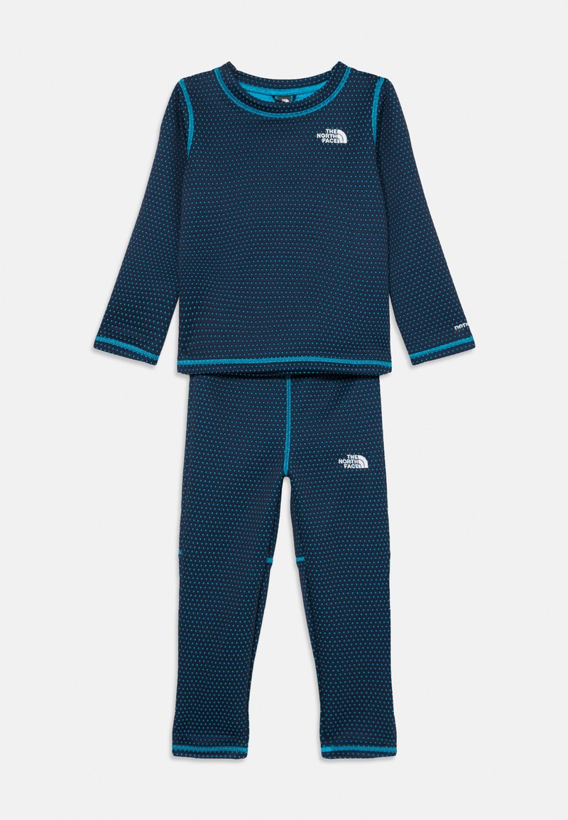 Conjunto térmico azul-marinho com mangas compridas e leggings, apresentando um design texturizado e costuras em azul-claro contrastantes. Logos em ambas as peças.