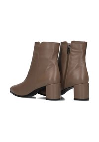 Een paar bruine leren enkelboots met blokhakken en zijritsen, weergegeven van de achterkant en zijaanzicht op een witte achtergrond.