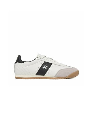 Hvid lavtsiddende sneaker med sort stribe og logo, beige ruskindståkappe og gummisål, sidevisning på hvid baggrund.
