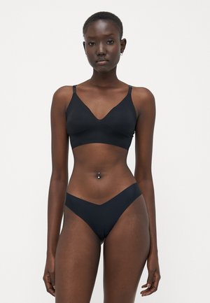 Bralette nera senza cuciture con scollatura a V e spalline regolabili, abbinato a slip bikini a vita bassa con taglio a V.
