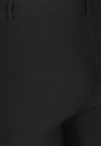 Schwarze Leggings aus elastischem Stoff, mit einer glatten Textur und hohem Bund, verstärkten Nähten und einer engen Passform.