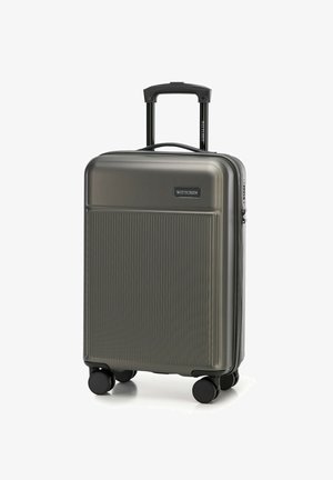 Hard-shell koffer in donkergrijs met een gestructureerd ribbelontwerp, uitschuifbare handgreep en vier zwarte wielen voor mobiliteit.