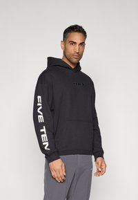 Sweatshirt preta com capuz e bolso frontal, com o texto "5.10" no peito e "FIVE TEN" em branco na manga. Corte casual e textura cómoda.