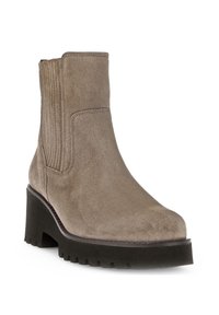 Beige suède enkellaars met ribbelpanelen aan de zijkanten, ronde neus en een chunky zwarte plateauhak. Geprofileerde zool voor grip en stabiliteit.