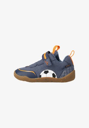 Baskets bleu marine pour enfants avec des accents orange, une bride auto-agrippante et un dessin de ballon de football noir et blanc sur le côté.