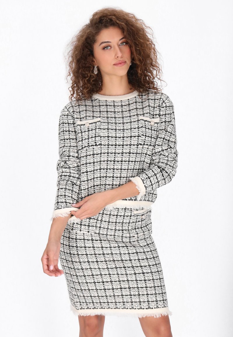 Fekete-fehér kockás, két részes szett, texturált kötött anyagból, bojtokkal és két mellzsebbel.