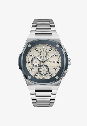 Sølv rustfrit stål ur med ottekantet kasse, blå urskive, teksturerede beige timeindikatorer og chronograph underdials. Metalrem.