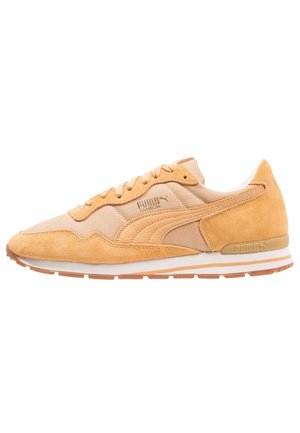 Jasnobrązowy sneaker Puma z zamszowym i materiałowym wzorem, z przodu sznurowany, z białą podeszwą i jasnobrązowym bieżnikiem widocznym z boku.