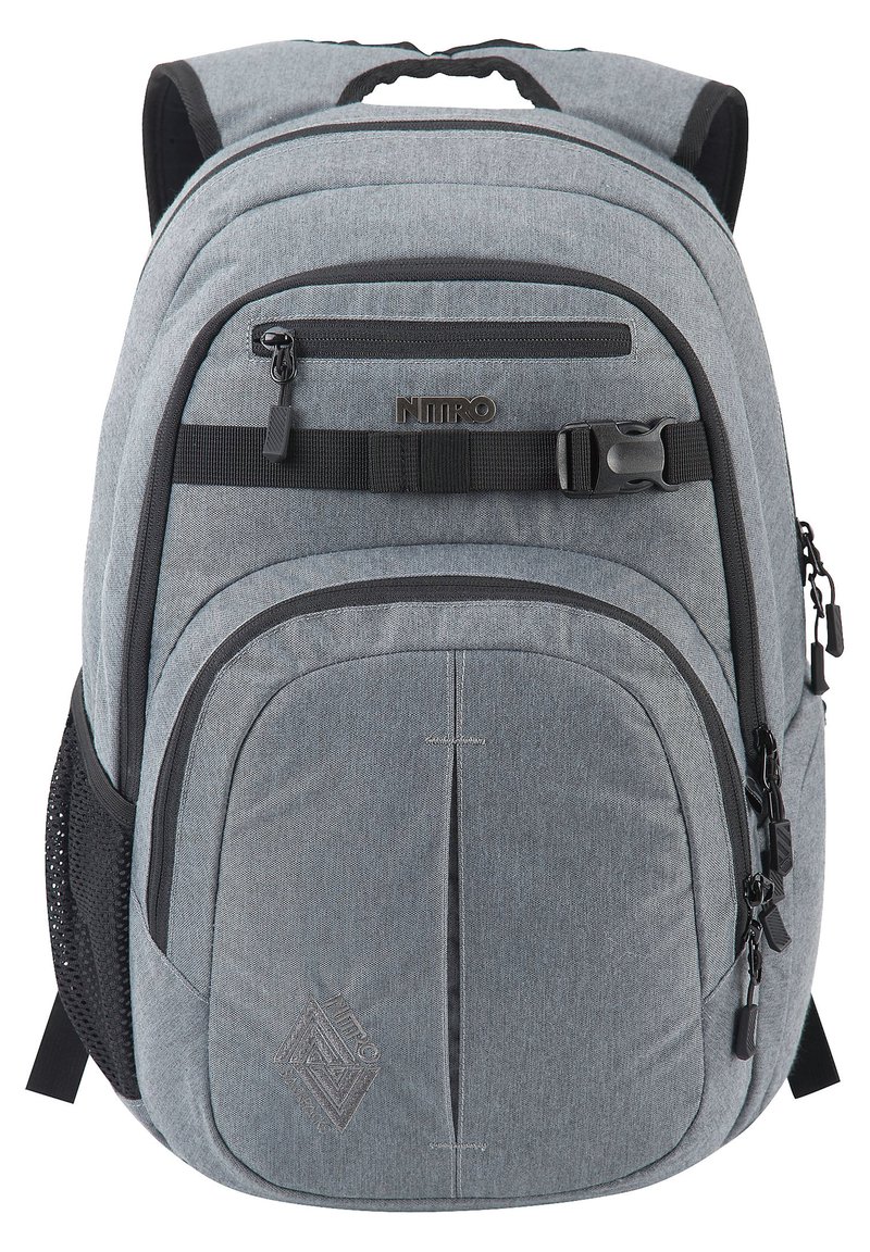 Mochila de tela gris con múltiples compartimentos con cremallera, espalda acolchada, correas ajustables y bolsillo lateral de malla. Presenta detalles de logotipo y costuras.