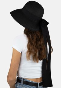 Schwarzer breitkrempiger Hut aus gewebtem Material, mit einem glatten Band und einer langen Schleife auf der Rückseite.