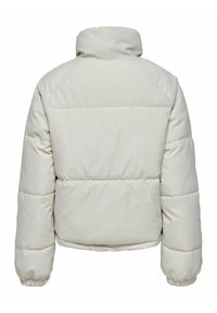 Chaqueta acolchada en beige claro con cuello alto, textura acolchada y puños elásticos. Diseño corto con acabado suave y mate.