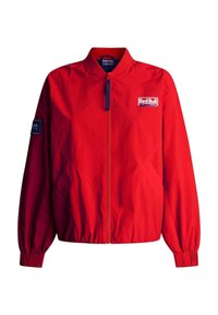 Veste bomber zippée rouge avec poignets élastiques, arborant le logo Red Bull Racing sur la poitrine et un patch sur la manche gauche.