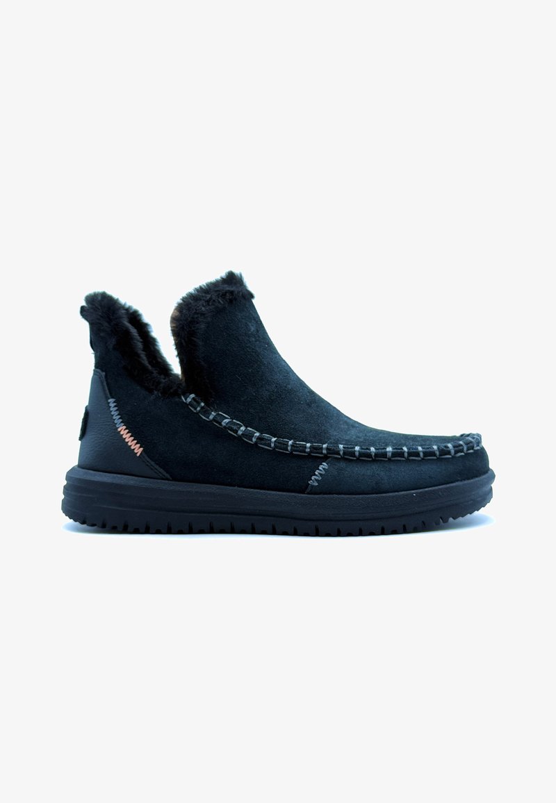 Zwarte suède enkellaarsjes met een faux fur voering, accentueerde stiksels en een rubberen zool, met een ronde neus en een gebogen ontwerp.