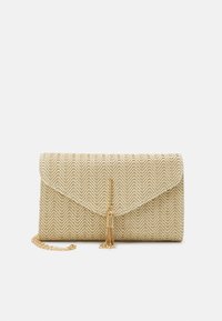 Sac pochette beige tissé avec motif chevron, détail de pompon doré et une sangle chaîne dorée partiellement visible sur fond blanc.