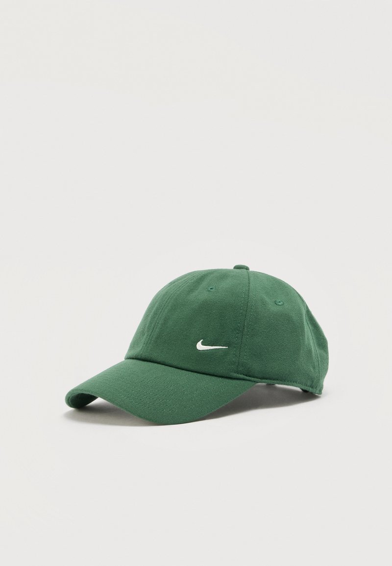 Πράσινο καπέλο μπέιζμπολ Nike με καμπυλωτή γείσο και λευκό λογότυπο swoosh στο κέντρο του μπροστινού πάνελ, σε απλό ανοιχτό φόντο.