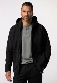 Zwarte fleece hoodie met rits, zachte textuur, kangoeroezakken en een grijs henley shirt eronder. Eenvoudig ontwerp met een capuchon.