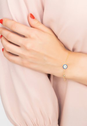 Bracciale in oro con un centro di pietra preziosa rotonda blu e bianca, catene delicate e un piccolo gancio regolabile.