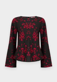 Blouse noire à manches longues avec motif floral rouge, encolure ronde, manches et ourlet légèrement évasés.
