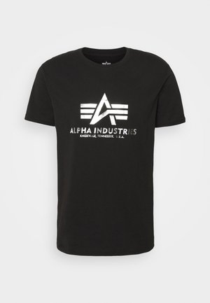 Schwarzes Baumwoll-T-Shirt mit silbernem Drucklogo, das drei horizontale Streifen und den Text "ALPHA INDUSTRIES, KNOXVILLE, TENNESSEE, U.S.A." zeigt.