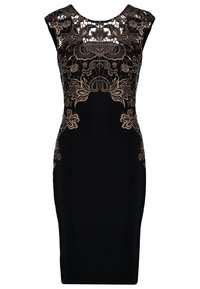Svart klänning med intrikat guldbroderi längs halsringningen och bysten. Figursydd siluett, ärmlös design, slät textur.