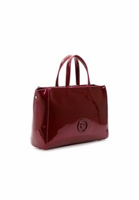 Sac fourre-tout bordeaux brillant avec deux poignées, de forme rectangulaire, texture lisse et accent logo circulaire à l'avant.
