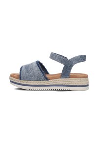 Blauwe schuifsandaal van denimachtige stof, met rafelige randen, een enkelsband en een beige geweven espadrillesole met een rubberen onderkant.
