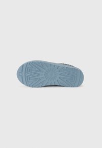 Suola della scarpa realizzata in un materiale gommato di un blu chiaro, caratterizzata da un motivo testurizzato e un design scanalato per garantire la presa. Nessun logo o marchio visibile.