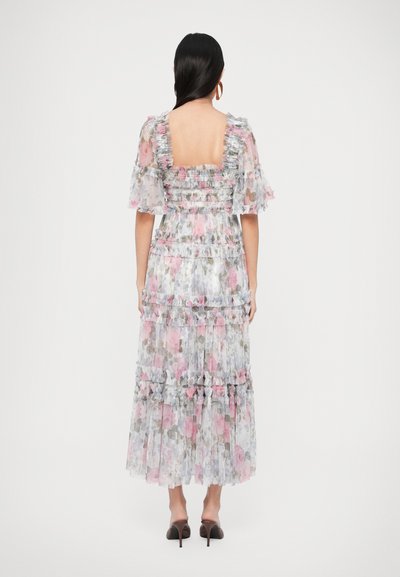 Rochie maxi florală dintr-un material ușor și transparent, cu mâneci volanate și straturi suprapuse. Prezintă o spate pătrată și accente roz, gri și verzi.