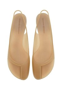 Transparent beige sandals with a sleek, minimalist design. Made of smooth, flexible material featuring a low cut and slingback style.