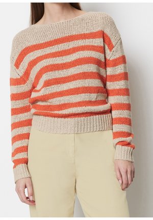 Beige och orange randig stickad tröja som bärs med ljusbeige byxor, visad från axlar till höfter mot vit bakgrund.