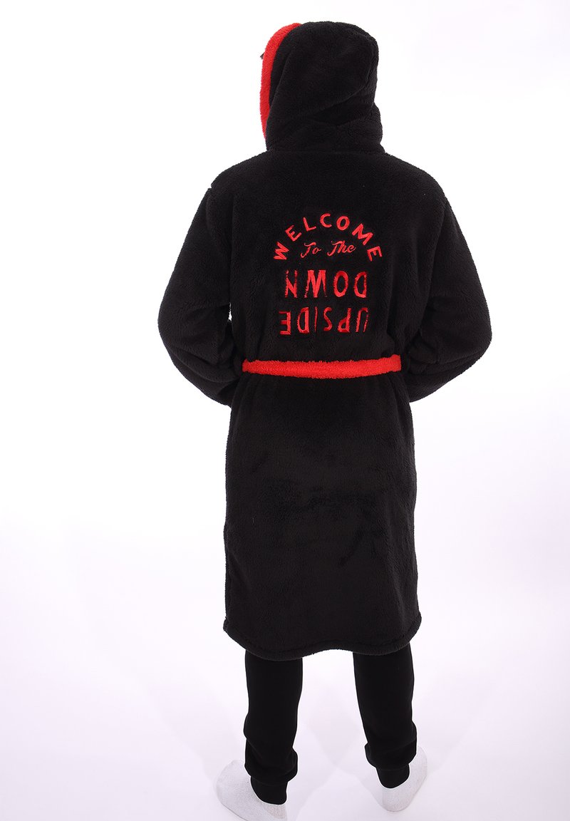 Accappatoio in pile nero con dettagli rossi, dotato di cappuccio e con il testo "BENVENUTO NEL MUNDO INVERO" ricamato in rosso sul retro.