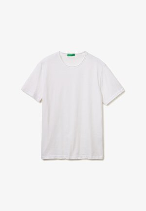 Effen wit T-shirt met korte mouwen en ronde hals, plat neergelegd, met een groen etiket bij de kraag met de tekst "United Colors of Benetton."