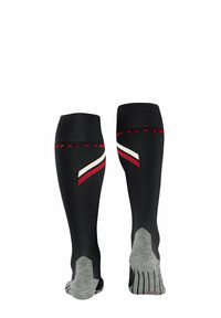 Chaussettes de sport montantes, noires avec des rayures diagonales rouges et blanches, dotées de semelles rembourrées grises et de grips texturés. Nom de marque sur le poignet.