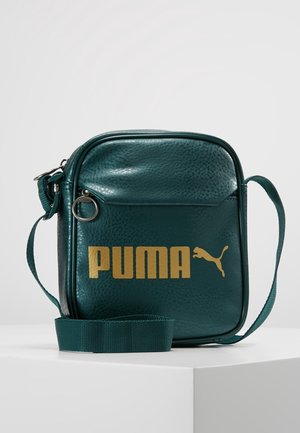 Lille turkis crossbody taske med justerbar rem, tekstureret finish, lynlåslomme foran og guld Puma-logo på fronten.