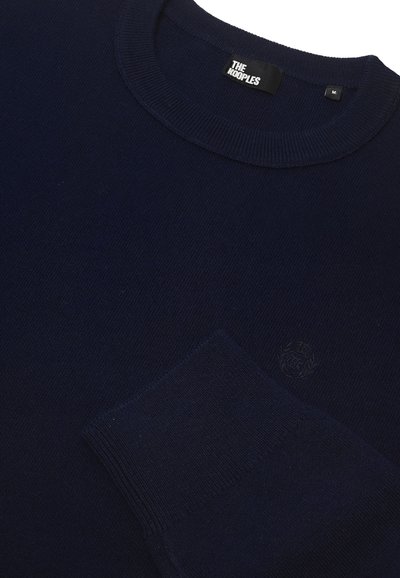 Marineblauwe gebreide trui met een ronde hals, ribgebreide manchetten en een subtiele logo op de borst. Gemaakt van zachte, gestructureerde stof.