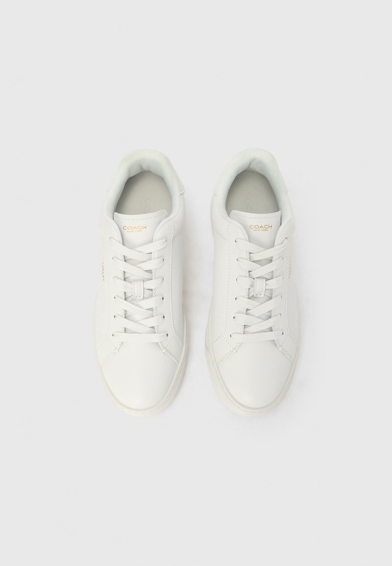 Baskets en cuir blanc à texture lisse, bout rond et lacets plats. Présentent un marquage discret sur la languette et un col matelassé.