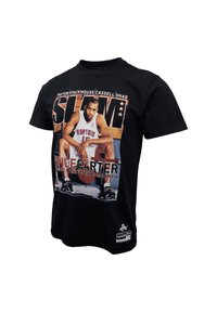 T-shirt in cotone nero con stampa grafica che raffigura un giocatore di basket. Il design include testo e dettagli in bianco e arancione.