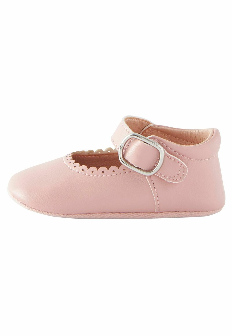 Pink leather Mary Jane shoe with scalloped edges, a round toe, and a silver buckle strap. Smooth texture and minimalistic design.